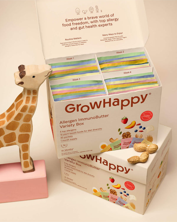GrowHappy allergen immun butter variety box with colorful packaging and a giraffe figurine.